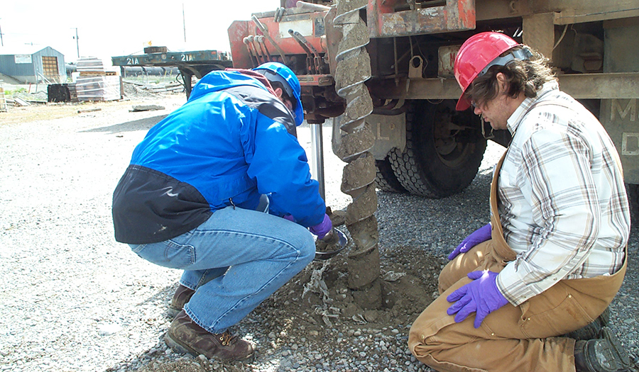 Gary Icopini and Nick Tucci collecing drill cuttings from auger